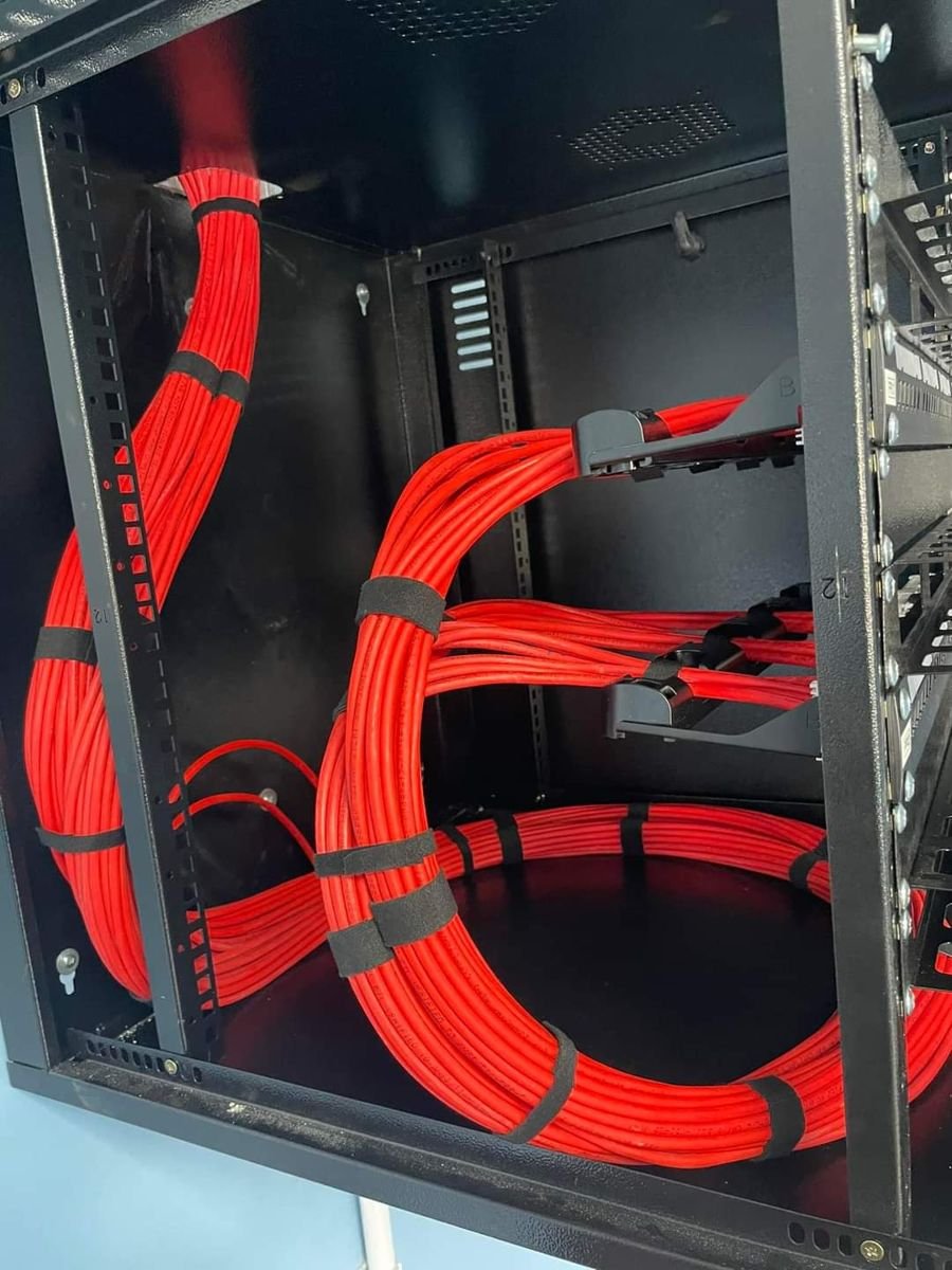 Interior do rack com feixes de cabos vermelhos presos com velcro